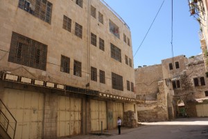 a Jewish settler standing beside an abandoned apartment